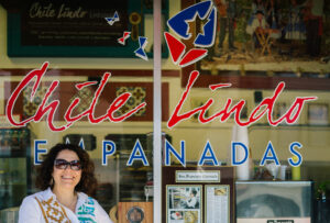 Paula Tejeda, Chile Lindo Owner, posing in front of her restaurant